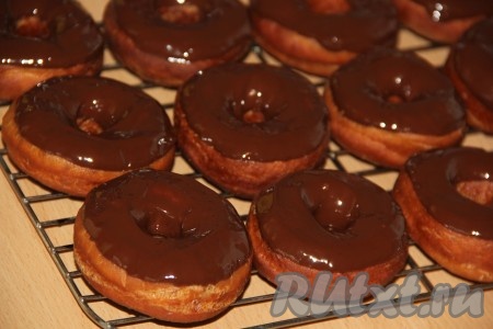 Обмакнуть пончик в растопленный шоколад и выложить на решётку. Затем по желанию можно посыпать пончики цветной посыпкой.
