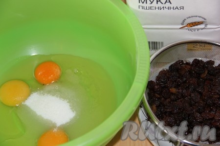 В глубокую миску вбить яйца, добавить сахар и соль. Изюм положить в дуршлаг, обдать кипятком, дать воде хорошо стечь.