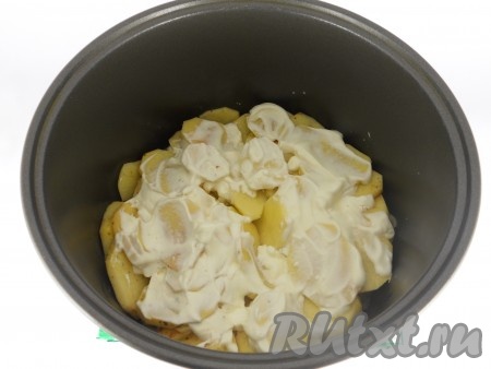 После окончания программы "Жарка" нарезанную картошку выложить в чашу мультиварки на шампиньоны, смазать сверху сметаной, влить воду, крышку мультиварки закрыть.
