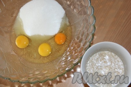 Молоко слегка подогреть. Всыпать в молоко дрожжи, добавить 2 столовые ложки сахара, всё перемешать. Оставить дрожжи в тепле на 15 минут, для того чтобы дрожжи ожили. На поверхности молока образуется пышная, пузырчатая шапка. В глубокой миске соединить яйца и сахар. Хорошо перетереть яйца с сахаром до однородного состояния.
