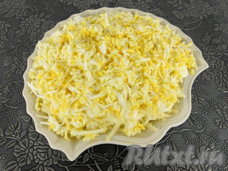Сыр также смазать майонезом и последним слоем выложить натертые на средней терке вареные яйца.