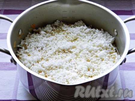 Выложить в кастрюлю рис, разровнять, накрыть крышкой и готовить еще 20-25 минут до готовности риса.
