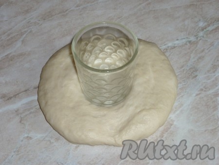 Подошедшее тесто разделить на 7-8 равный частей. Каждую часть раскатать в лепёшку и в середину вставить рюмочки (маленькие стаканчики), дно которых смазать растительным маслом.

