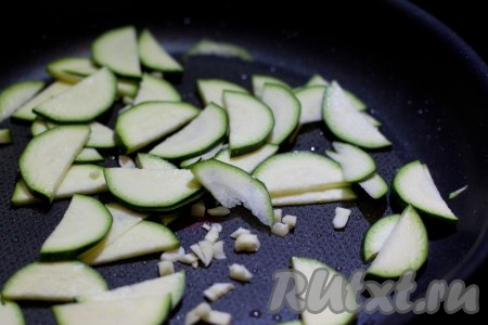 Цукини нарежьте тонкими полукружками, чеснок мелко измельчите. Разогрейте оливковое масло в сковороде и обжарьте в ней цукини с чесноком, где-то минут 5, периодически помешивая.
