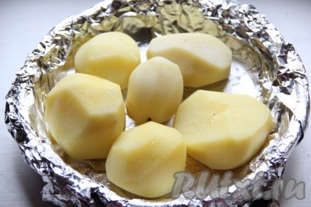 Картофель выложить в форму для запекания, застеленную фольгой, смазать 1-2 столовыми ложками растительного масла.