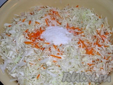 Поместить морковь и капусту в большую миску, засыпать сахаром и солью.
