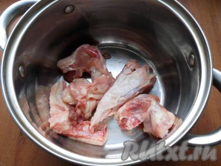 В кастрюлю выложить вымытые кусочки мяса, влить 1,5 литра воды, поставить на сильный огонь. После закипания воды, убрав с поверхности бульона пену, варить мясо 25-30 минут на небольшом огне. Сварившиеся кусочки курицы достать из бульона, дать немного остыть. Куриный бульон, если необходимо, процедить и вернуть в кастрюлю. Слегка остывшее мясо отделить от костей, нарезать на части, добавить в кастрюлю с бульоном. Кастрюлю с куриным бульоном и мясо поставить на сильный огонь. Довести бульон до кипения.