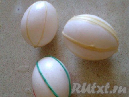 В кастрюлю положите  луковую шелуху и отварите в течение получаса. Затем шелуху выбросите, отвар остудите.

Из пальчиков хозяйственной или медицинской  перчатки нарежьте  полоски шириной 0,7 см. На яйцо наденьте по 2-3 нарезанных полоски. 