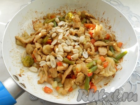 Затем к курице добавить овощи, перемешать и протушить все вместе 3-4 минуты. Далее добавить арахис.