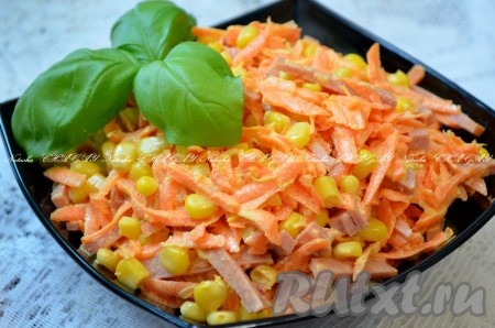 Выложить салат с копченой колбасой и морковью в салатник, охладить. Перед подачей украсить зеленью.

