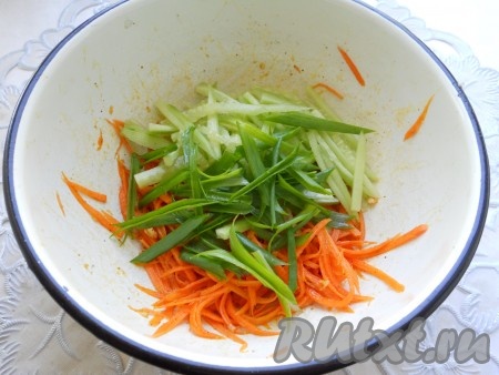 Хорошо морковь перемешать и оставить на 10-15 минут. Огурец свежий очистить и порезать тонкой соломкой, перья зеленого лука порезать длинными полосочками (длиной по 4-5 см). Огурчик и лук добавить к моркови.
