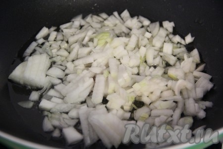 Очищенный лук мелко нарезать. В глубокую сковороду влить немного растительного масла и поставить на огонь. На разогретую сковороду выложить лук и обжарить его, периодически помешивая, до мягкости (в течение 4-5 минут).