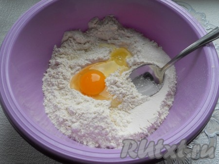 Для приготовления теста просеять муку в глубокую миску, сделать небольшое углубление. Добавить яйцо, соль, соду и сахар.

