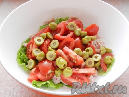 Оливки разрезать пополам и добавить в салат из ветчины и помидоров.
