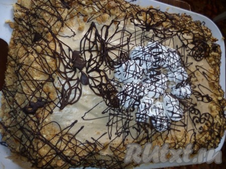Лист с рисунками нужно поставить в холодильник до застывания шоколада, затем очень быстро снять фигурки с бумаги и сразу установить на торт, потому что шоколад тает в руках очень быстро. Снова поставить Киевский торт в холодильник. 
