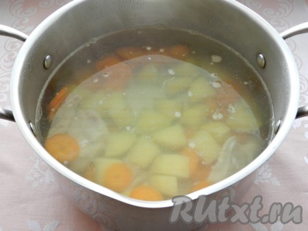 Процеженный бульон довести до кипения, посолить, поперчить, добавить картофель и морковь, варить 15 минут.
