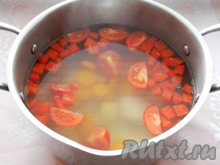 Затем добавить в кастрюлю перец, нарезанный кубиками, и четвертинки помидоров. Варить еще 5 минут.