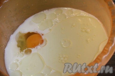 В отдельной миске смешать кефир и соду. Хорошо перемешать и оставить минут на 5, за это время кефир погасит соду. Затем добавить 4 столовые ложки растительного масла и яйцо.