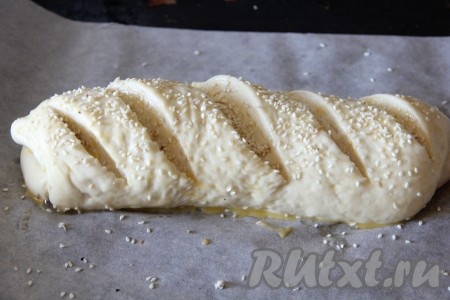 Оставить тесто для расстойки на 40 минут. На тесте сделать надрезы, смазать взбитым желтком и присыпать кунжутом.