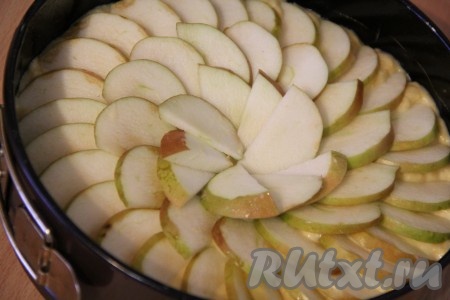 Смазать форму для выпекания растительным маслом. Тесто разровнять по всей ширине формы. Вымыть яблоки, удалить сердцевины и тонко нарезать. Выложить слой из яблок поверх теста. Выпекать тыквенный пирог в разогретой духовке при 180-200 градусах приблизительно 45 минут (следите за выпечкой, так как время приготовления зависит от вашей духовки). Готовность пирога проверяем сухой зубочисткой.
