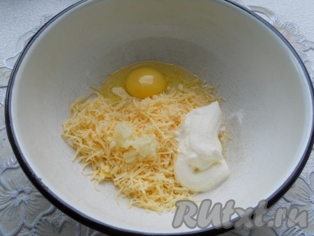 К яйцу добавить сметану, чеснок, пропущенный через пресс, и сыр, натертый на средней терке.
