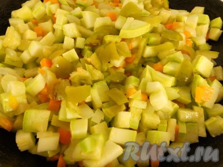 Добавить в сковороду кабачки и сладкий болгарский перец, немного посолить. Обжаривать овощи вместе при помешивании 5-7 минут.