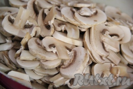 Грибы промыть под проточной водой и нарезать тонкими пластинками. Выложить грибы на сковороду с добавлением растительного масла.