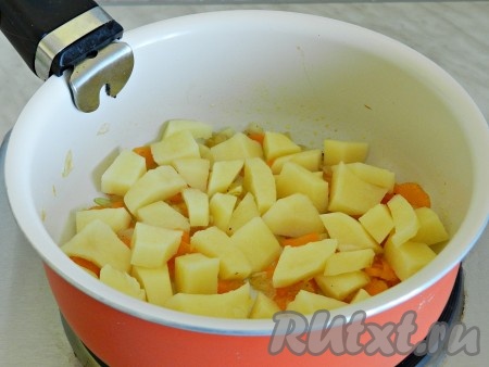 В небольшом сотейнике разогреть растительное масло и обжарить сначала лук, чеснок и морковь до прозрачности. Посолить и поперчить. Добавить очищенный и нарезанный кубиками картофель.