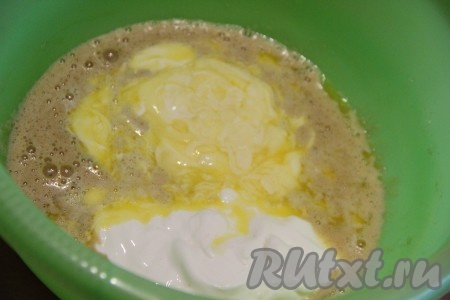  Перемешать яйцо с сахаром. Маргарин или масло растопить и слегка остудить. Добавить в миску растопленное масло и сметану. Всё перемешать вилкой или венчиком до однородного состояния.