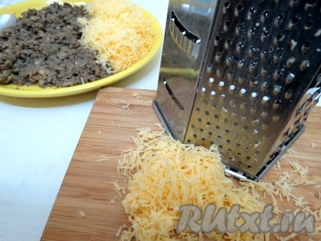 Сыр натираем на мелкой тёрке и добавляем в грибную массу. Тщательно перемешиваем и только тогда перчим и солим, учитываем, что сыр солёный. Не пересолите!
