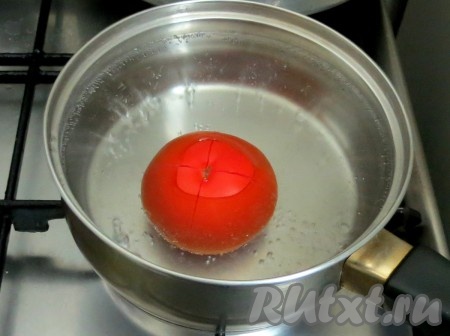 В верхней части помидора надрезаем крест на крест кожицу. Отправляем помидор в кипяток, медленно считаем до пяти. Вынимаем помидор и выкладываем его в холодную воду.
