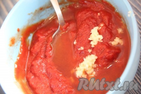 В глубокой мисочке соединить томатную пасту и воду. Добавить зубчик чеснока, пропущенный через пресс.
