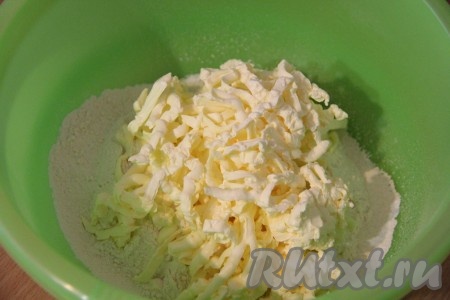 Муку просеять вместе с разрыхлителем в глубокую миску, добавить соль. Холодное масло натереть на крупной тёрке или порубить ножом на мелкие кусочки и добавить к муке.
