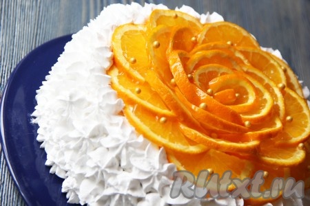 По желанию можно развести желе для торта и покрыть им апельсины. Затем часть сливок выложить в кондитерский мешок и оформить бока медовика рисунком из крема.