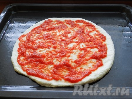 Противень смазать маслом. Из теста сформировать лепешку для пиццы, оставляя утолщения с краев. На лепешку выложить приготовленный томатный соус.
