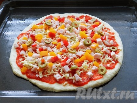 Затем выложить остальную начинку: балык, перец и оливки. Поставить пиццу в предварительно нагретую до 230-240 градусов духовку на 15 минут. Затем выложить на пиццу вторую порцию сыра и готовить еще 2-3 минуты, чтобы сыр расплавился.