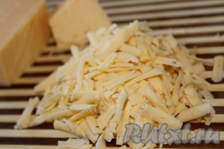 Натереть сыр на крупной терке. Часть сыра отложить (он нам понадобится для посыпки).
