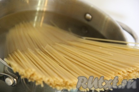 Выложить спагетти в кипящую подсоленную воду, перемешать, довести до кипения и варить до готовности (в течение 7-9 минут, точное время варки смотрите на упаковке спагетти, которые вы отвариваете) на небольшом огне, затем откинуть на дуршлаг и оставить на несколько минут, чтобы лишняя вода стекла.