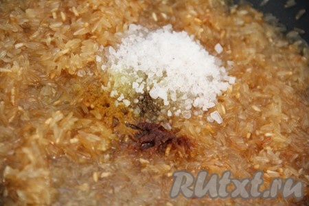 Как только рис приобретёт золотистый оттенок, нужно добавить специи и соль, тщательно перемешать.