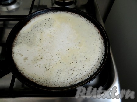 Перед жаркой первого блина смазываем сковороду растительным маслом. Наливаем немного тесто и жарим блин с одной стороны.

