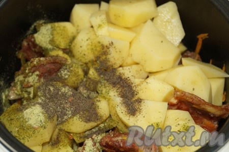 Картофель очистить, нарезать на небольшие кусочки и переложить в чашу мультиварки к овощам и копченым рёбрышкам, посыпать солью и специями.
