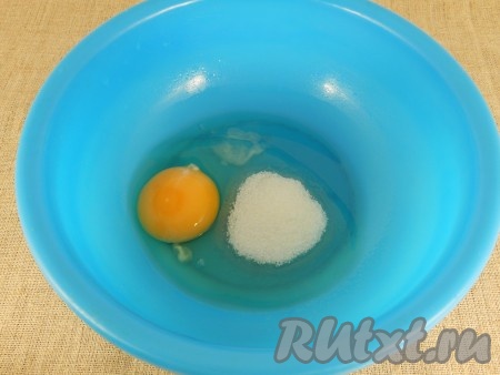 Изюм залить на 7-10 минут кипятком, затем воду слить, изюм обсушить. В миску разбить яйцо, добавить соль и сахар.
