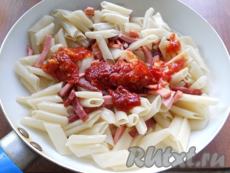 В сковороду выложить макароны и перемешать с колбасой. Добавить томатный соус (соус можете использовать любой, какой вам нравится - острый, кисло-сладкий и т.п.). 