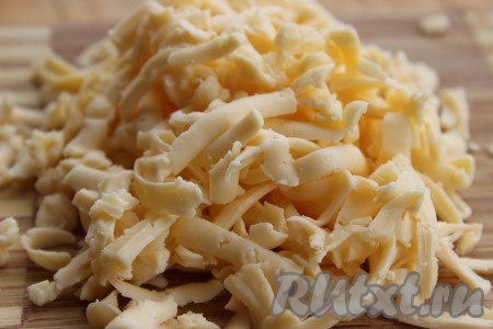Готовое слоеное тесто разморозить при комнатной температуре. Пока тесто размораживается, приготовим начинку. Сыр натереть на крупной терке.
