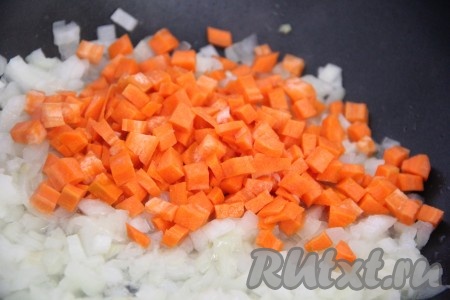 Обжарить лук, помешивая, до золотистого цвета. Морковь нарезать на мелкие кубики, по желанию можно натереть на крупной тёрке. Добавить морковь в сковороду к луку и хорошо перемешать. Обжарить овощи, иногда перемешивая, в течение нескольких минут.
