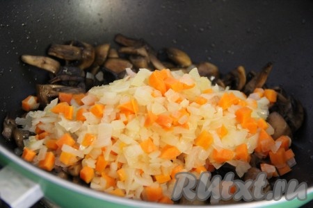 Добавить обжаренные овощи в сковороду к грибам и хорошо перемешать.