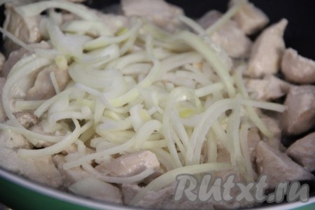 Добавить лук в сковороду и обжарить вместе с филе куриной грудки в течение пары минут.