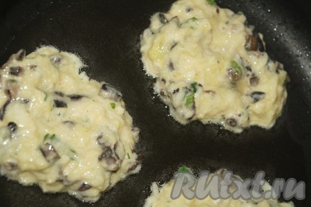 Жарить оладьи из кабачков с грибами на раскалённой сковороде на растительном масле, выкладывая столовой ложкой каждую оладушку.
