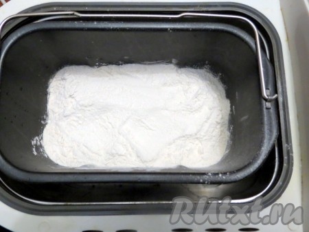 Муку просейте, добавьте к ней сухое молоко. Муку с молоком засыпайте так, чтобы она полностью покрыла жидкую часть. В разные углы положите соль и сахар.
