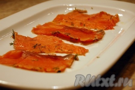 Нарезать очень вкусную красную рыбу тонкими ломтиками.